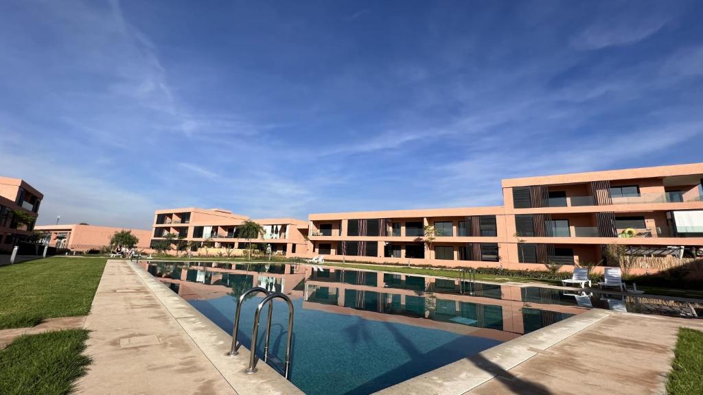 a building with a swimming pool in front of it at Luxueux appartement Golf City Rez-de-Jardin et Piscine in Marrakesh