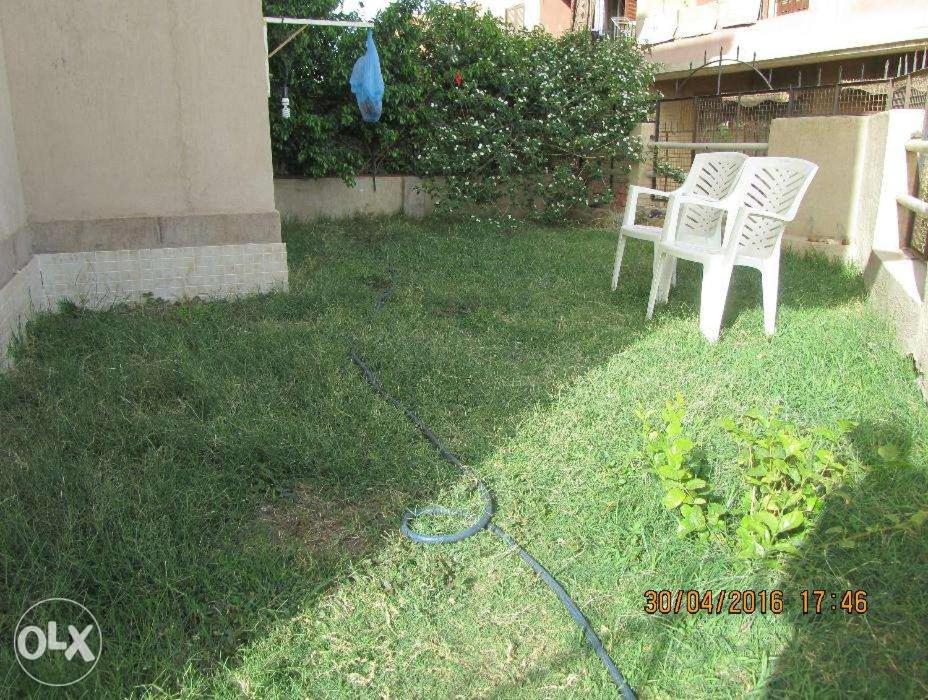 twee witte stoelen in het gras in een tuin bij شقة أرضي بحديقه بكمبوند راقي بالعبور in ‘Ezbet el-Insha