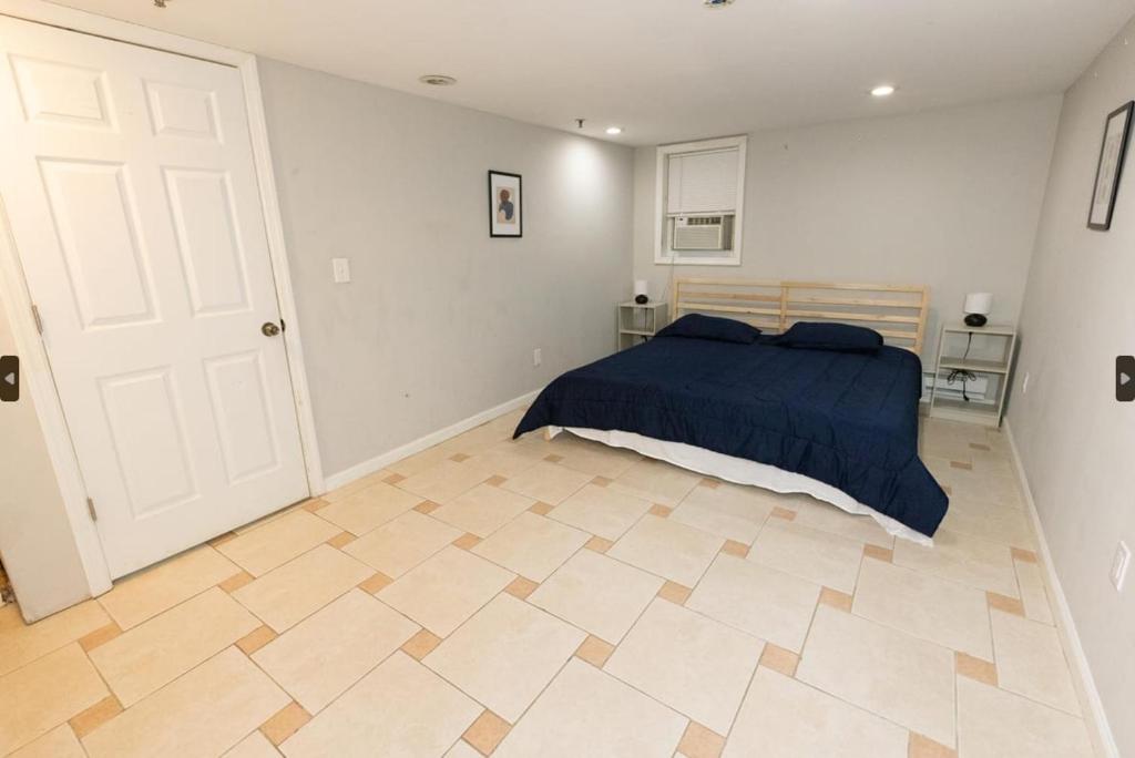 sypialnia z łóżkiem i podłogą wyłożoną kafelkami w obiekcie Bright 2-Bed Haven Close to NYC w mieście Jersey City