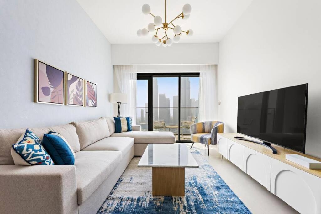 a living room with a couch and a tv at Burj Royale - Burj Khalifa View - 4m Walk to Dubai Mall in Dubai