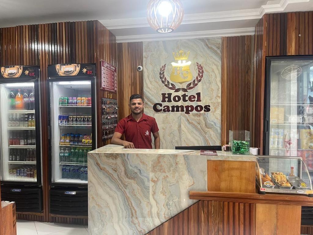Ein Mann steht hinter einer Theke in einem Hotel-Campusrestaurant. in der Unterkunft Hotel Campos in Itaituba
