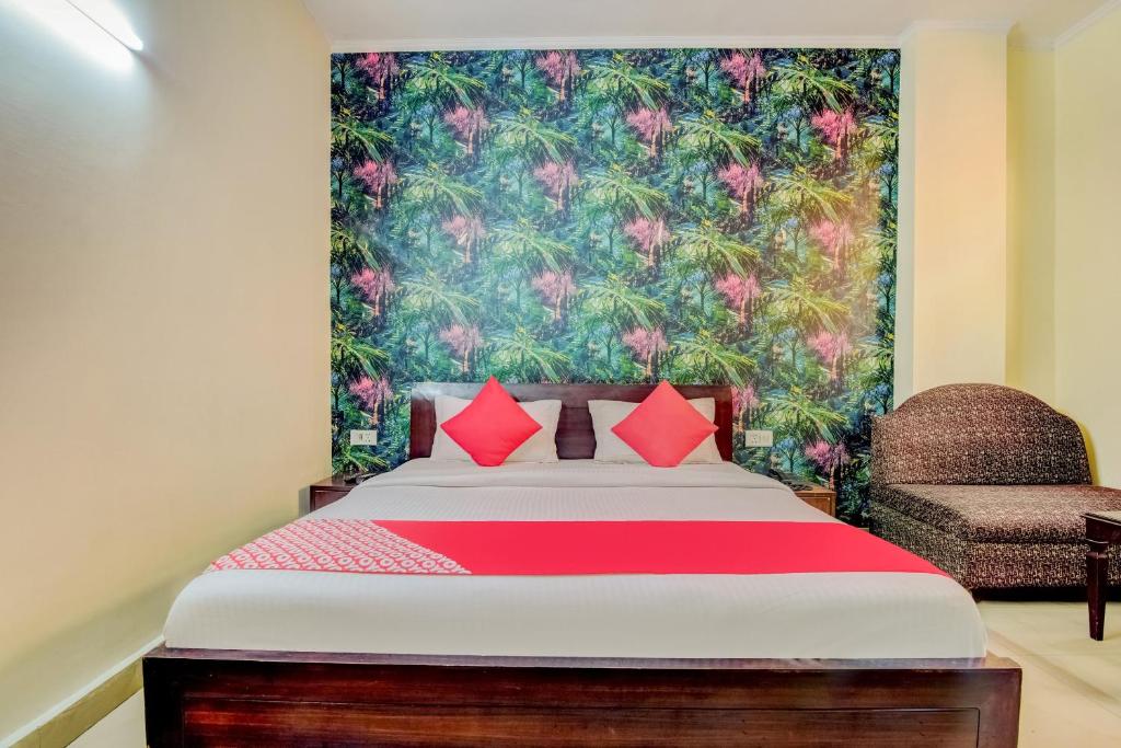 a bedroom with a bed with a large floral wallpaper at OYO Hotel Delhi Darbar in New Delhi