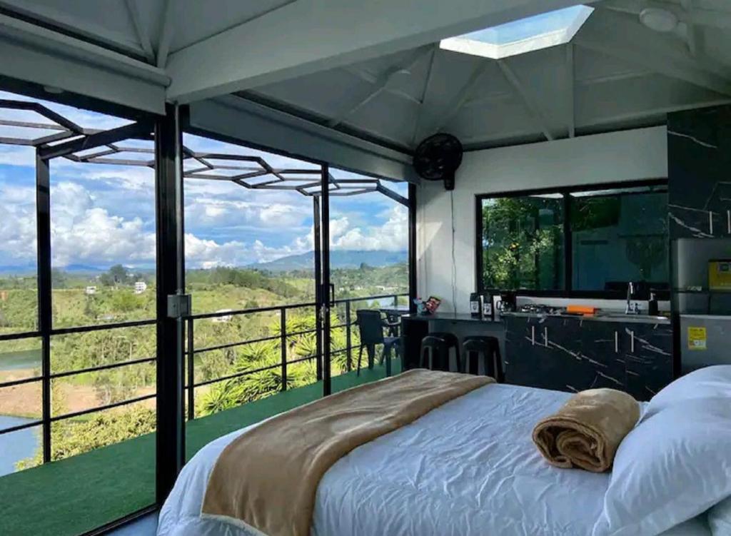 1 dormitorio con cama y vistas a las montañas en Suite Gold Rocks Glamping en El Peñol