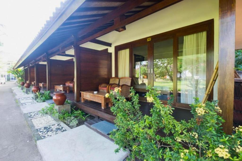 a house with a porch with a couch on it at Sidesratra 1 BR Classic Superior NE56 in Gili Air