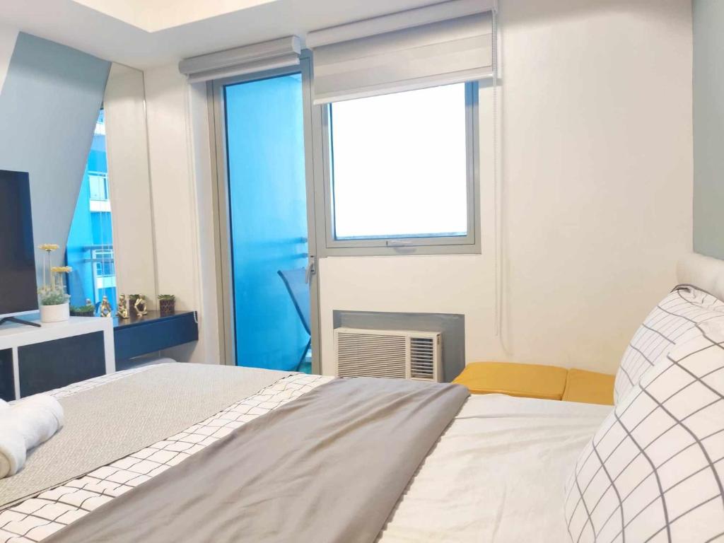 Un dormitorio con una cama grande y una ventana en Happy Modern Studio in Azure, en Lagundi