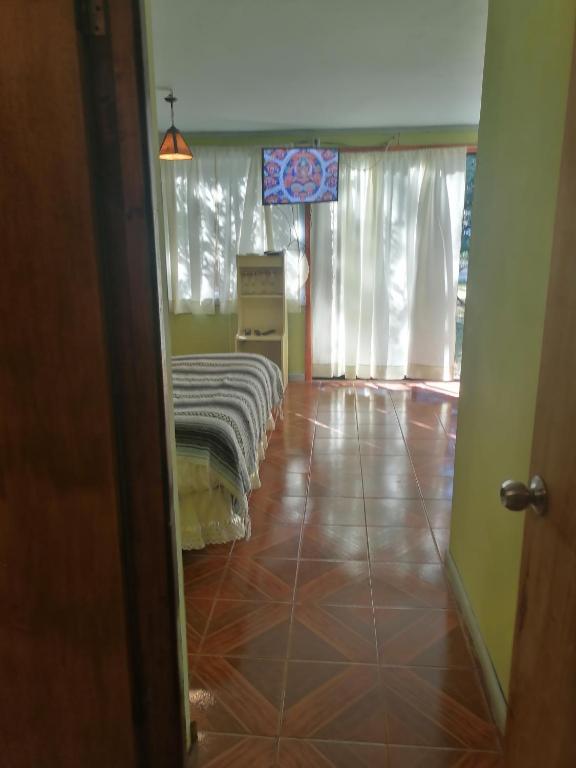 una camera con un letto su un pavimento piastrellato di Cisnes del tolten a Freire