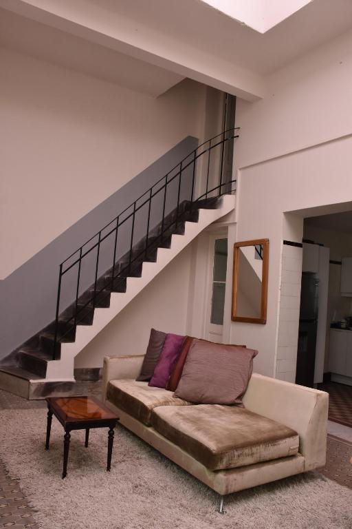 a living room with a couch and a staircase at Morada Montevideana in Montevideo