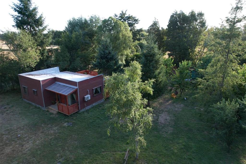 eine Luftansicht eines kleinen Hauses im Wald in der Unterkunft Cisnes del tolten in Freire