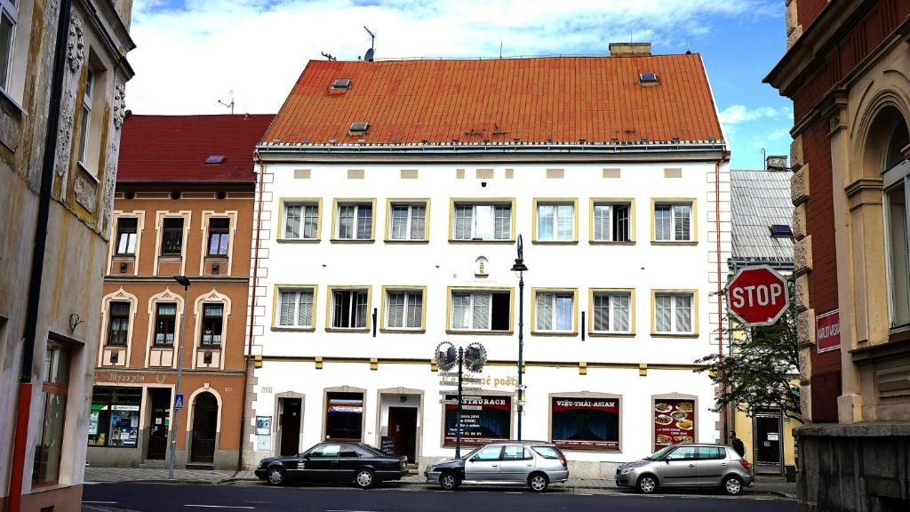 a white building with a red roof on a street at Ubytování in Karlovy Vary