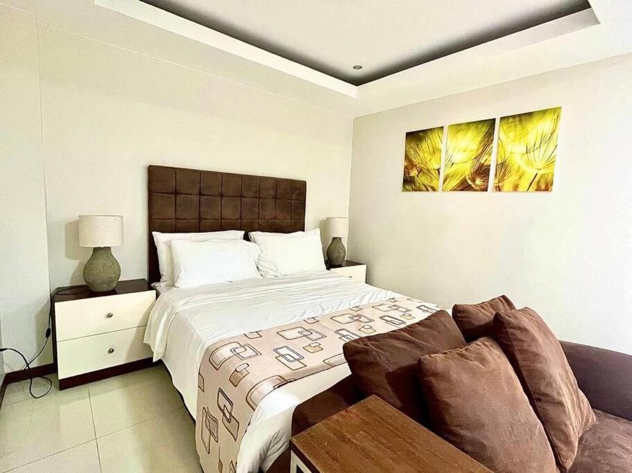 a bedroom with a large bed and a couch at Sheryll Escapes - 214 La Grande Studio, comfy hotel amenities with Netflix! in Angeles