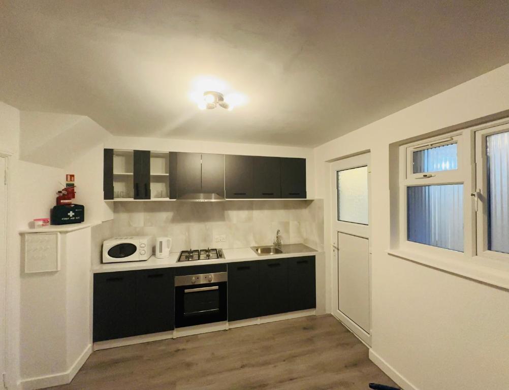 a kitchen with black and white appliances and a window at 9 probyn close in Bristol