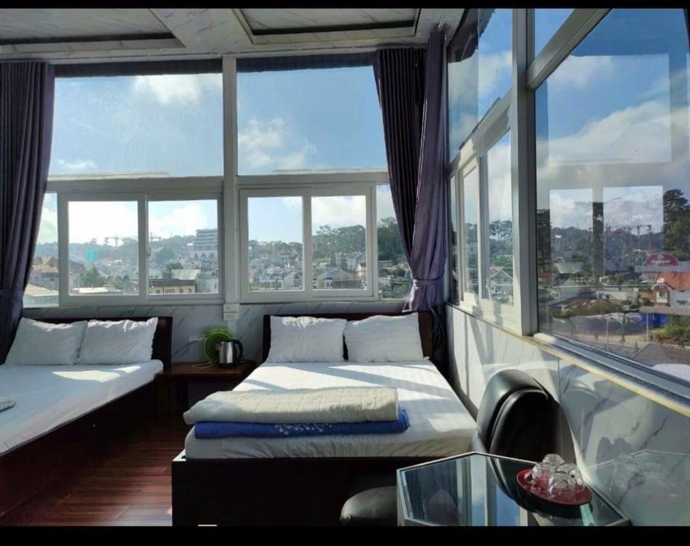 Hotel minh anh في Xuan An: غرفة كبيرة بسريرين ونوافذ كبيرة