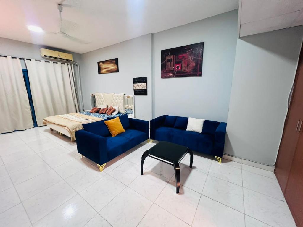 a living room with a bed and a couch and a table at Studio Apartment in Ajman 