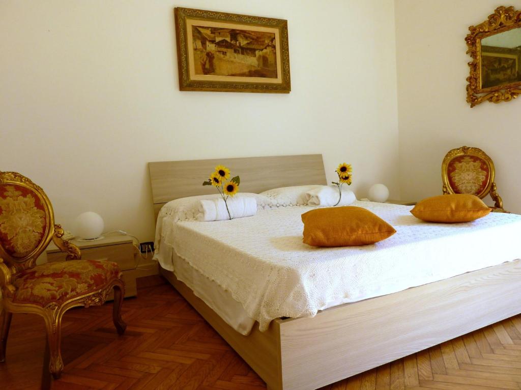 2 letti in una camera da letto con 2 sedie e 2 letti sidx sidx. di Un Giardino a Due Passi dal Mare a La Spezia