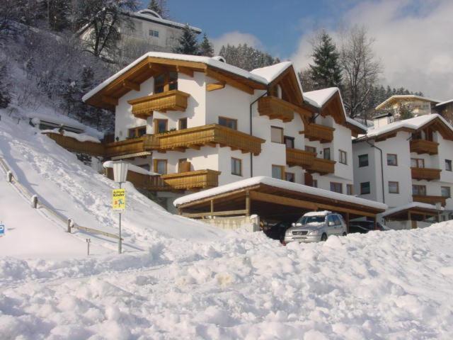 un gran edificio con nieve en el costado en Ferienwohnung Optimal, en Kaltenbach