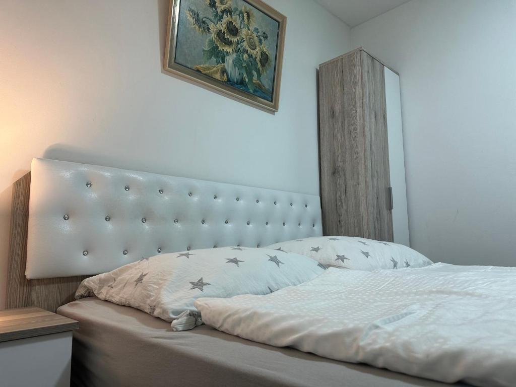 Schlafzimmer mit einem weißen Bett mit Kopfteil in der Unterkunft Friesdorfer Hof in Bonn