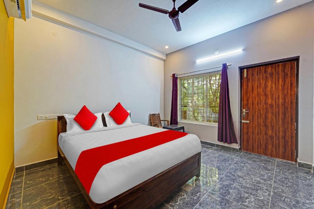 a bedroom with a large bed with red pillows at OYO Flagship Le Gith De Charme with swiming pool in Kottakupam