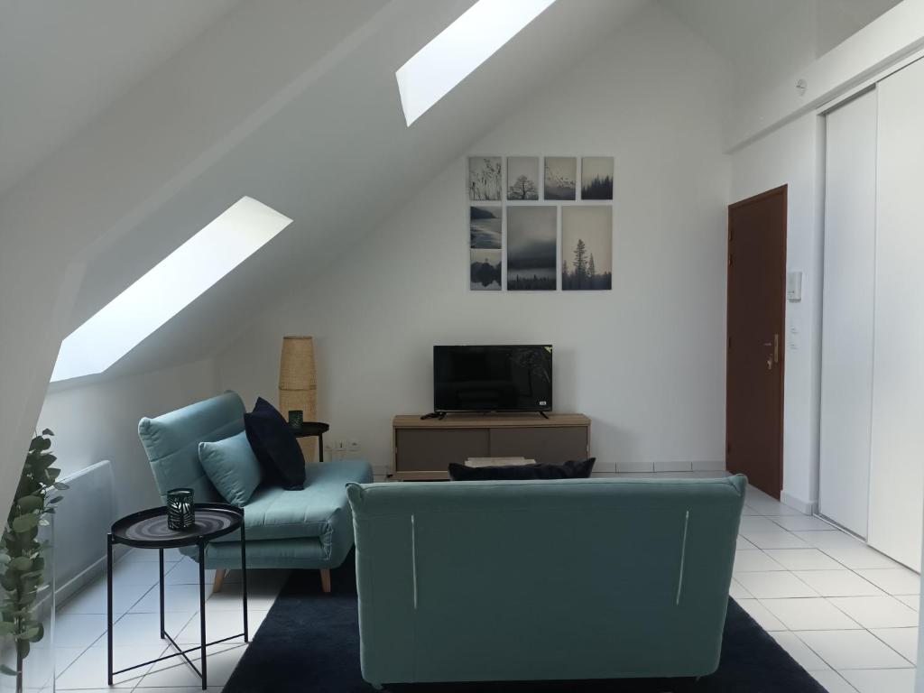 un salon avec un canapé bleu et une télévision dans l'établissement T2 Cozy Rungis - 15min de Paris !, à Rungis