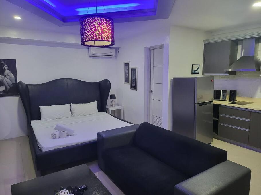uma sala de estar com uma cama e um sofá em Kandi studio by the pool. Housekeeping, Netflix! em Angeles