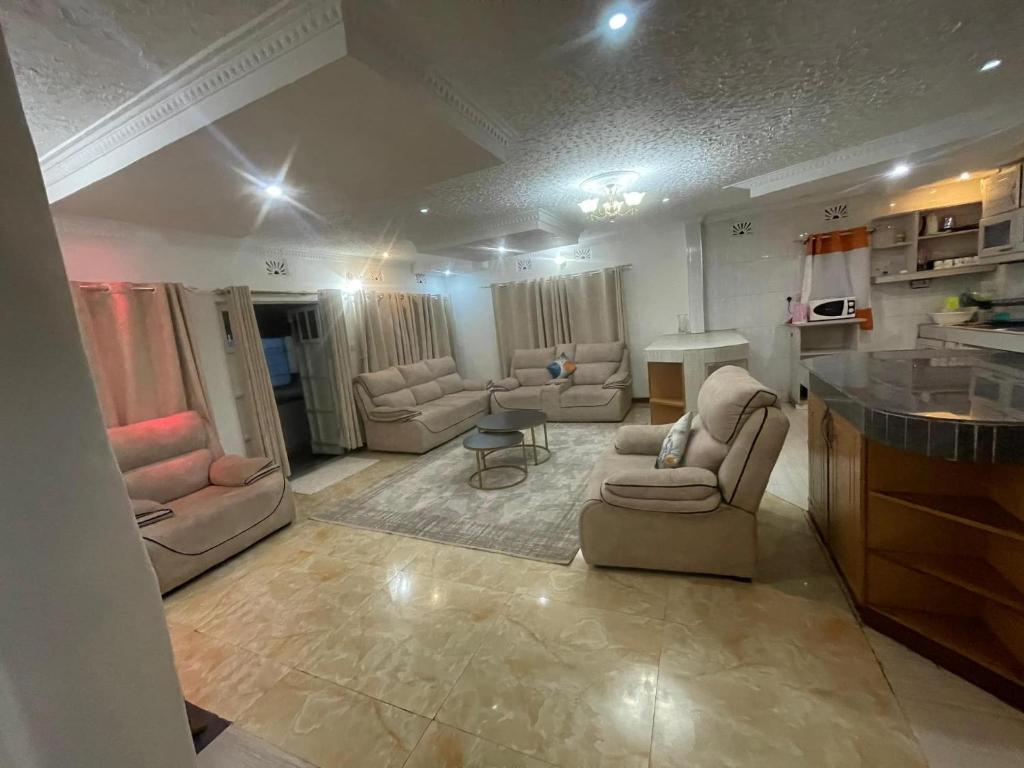 sala de estar con sofás y sillas y cocina en SERENE GUEST HOUSE en Eldoret