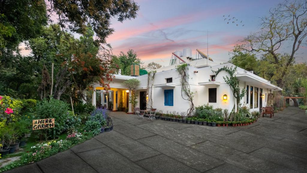 una casa blanca con un cartel delante en Lutyens Bungalow en Nueva Delhi