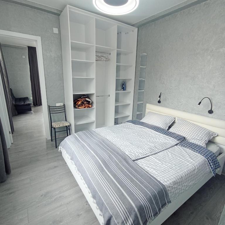a bedroom with a large bed with white shelves at Studio in Chakvi in Chakvi