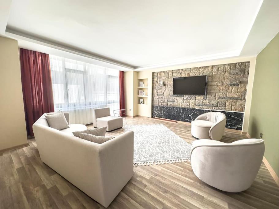 ein Wohnzimmer mit weißen Möbeln und einem Steinkamin in der Unterkunft 110-Peaceful in Ankara