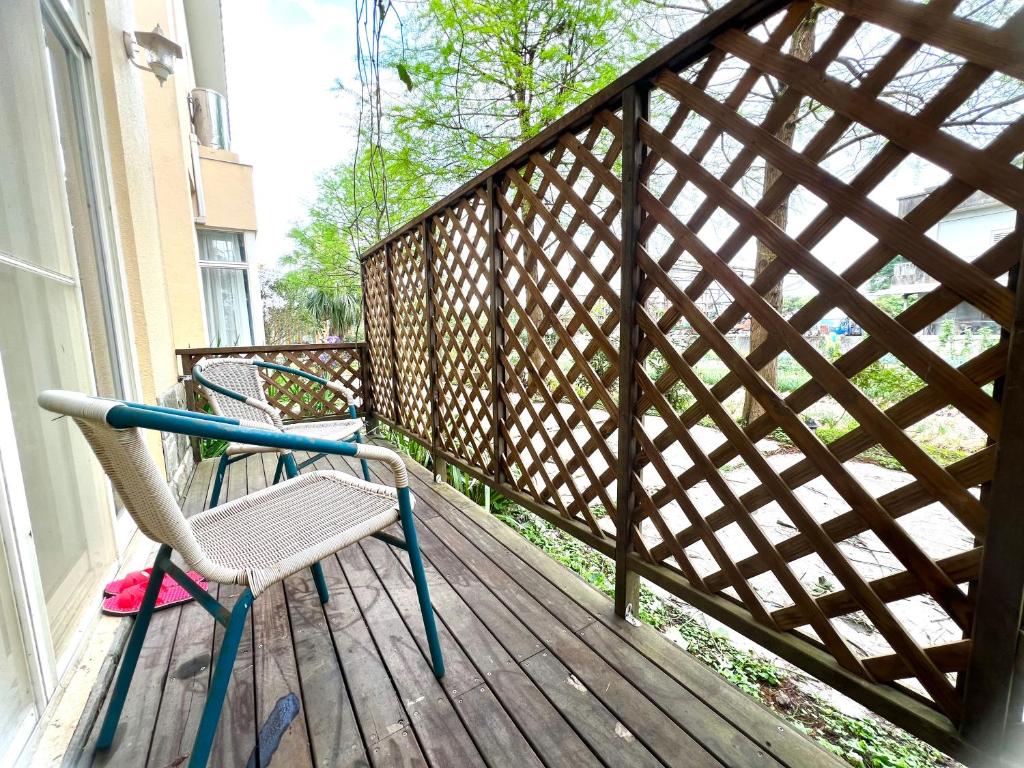 a wooden balcony with a chair on a porch at Annongriver B&amp;B in Sanxing