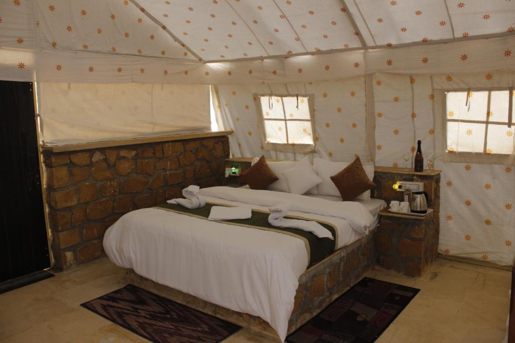 a bedroom with a large bed in a tent at Desert Life safari camp in Sām