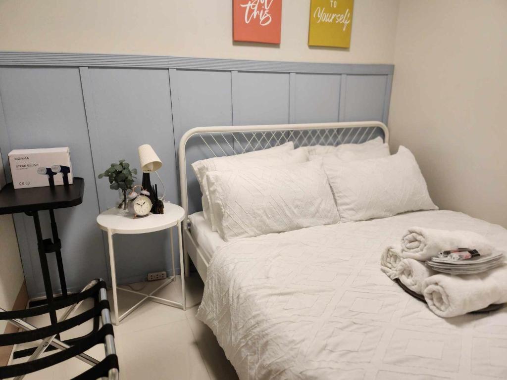 una camera con letto bianco e comodino di My Humble Abode at Shore 3 a Manila