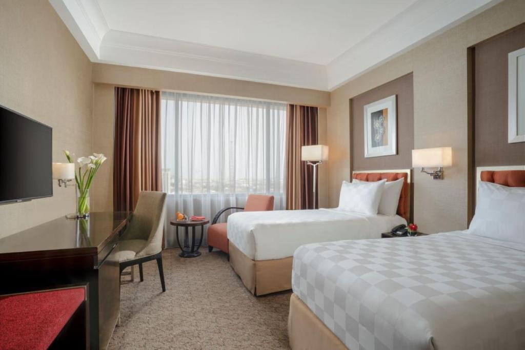 Postel nebo postele na pokoji v ubytování Hotel Ciputra Semarang managed by Swiss-Belhotel International