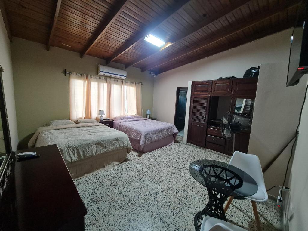 1 dormitorio con 2 camas y TV. en Familiar y Acogedor en San Pedro Sula