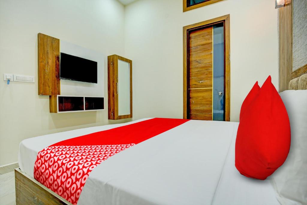 een rood kussen op een bed in een slaapkamer bij Super OYO Flagship Hotel Elista in Zirakpur