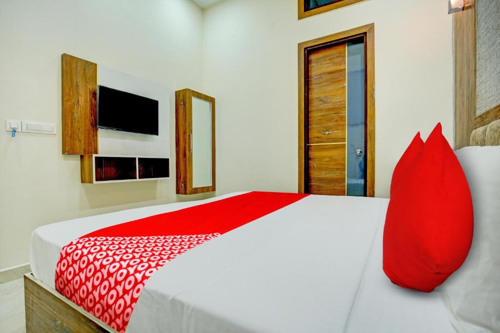 a red pillow sits on a bed in a bedroom at Flagship Hotel Elista in Zirakpur
