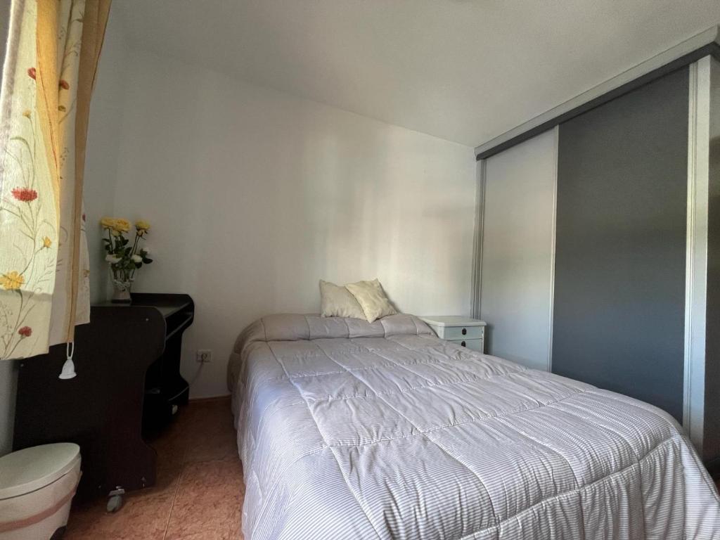 ein Schlafzimmer mit einem Bett mit einer weißen Bettdecke in der Unterkunft La casa de Antonia in Córdoba