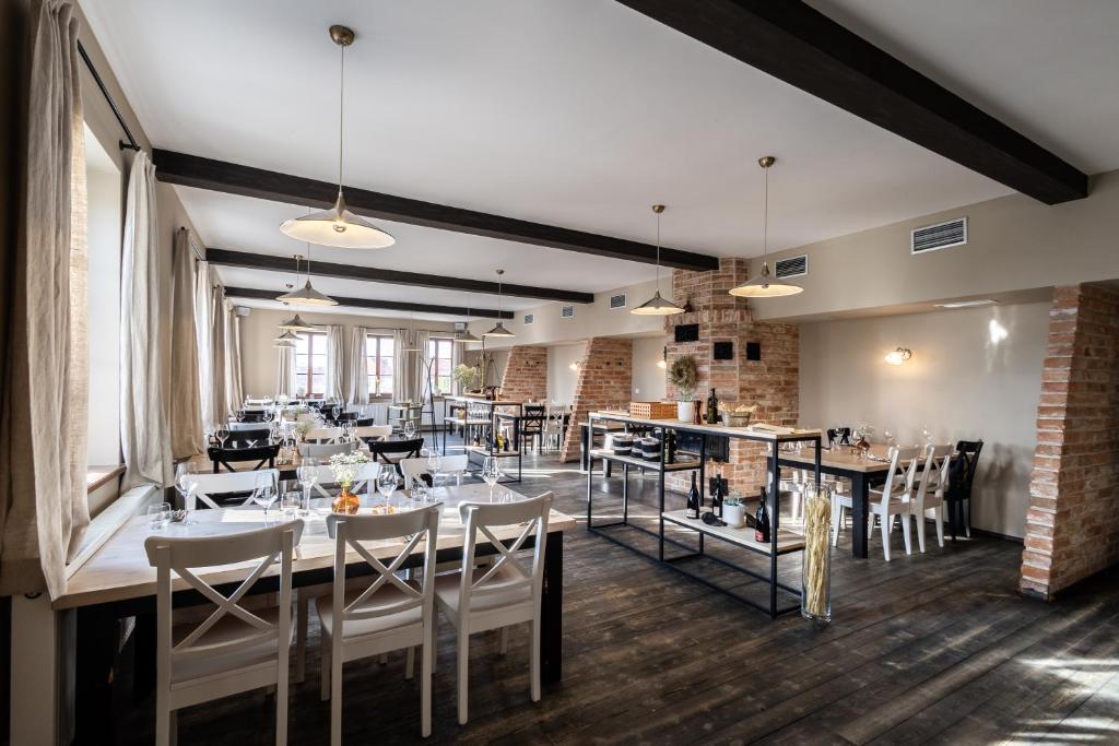 een eetkamer met tafels en stoelen en een bakstenen muur bij Hotel Tanzberg Mikulov in Mikulov