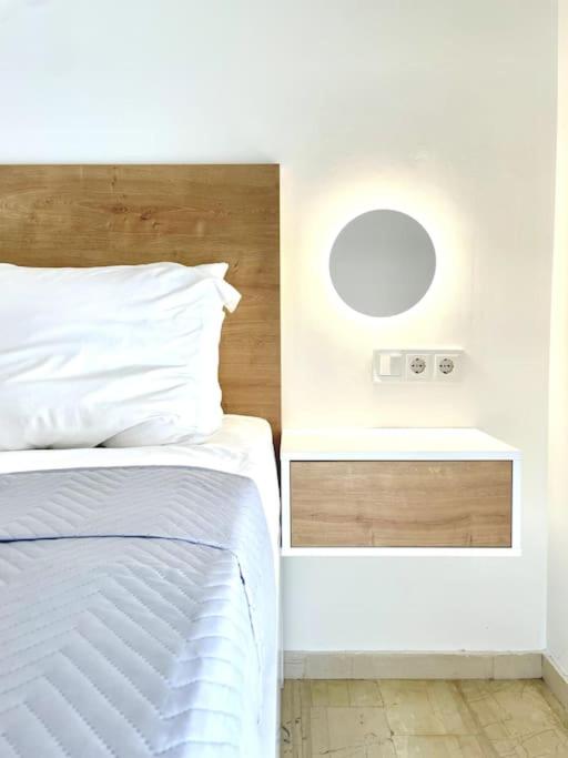 a bedroom with a white bed and a mirror at Yela apartment in Malia
