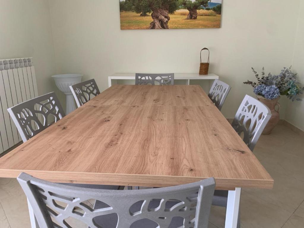 una mesa de madera con sillas en una habitación en Come Casa Tua, en Carovigno