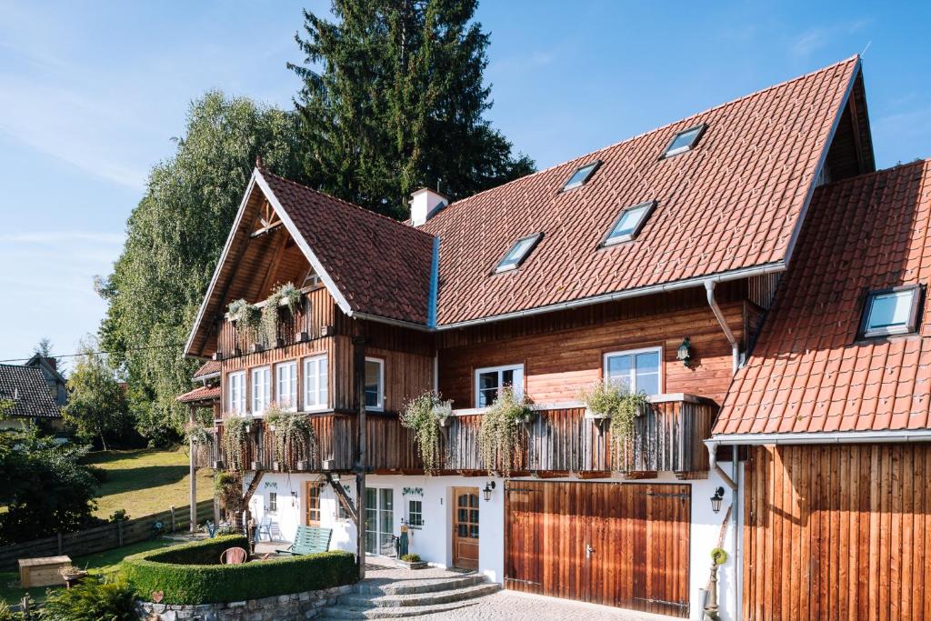 una gran casa de madera con una valla de madera en SCHILCHERLANDLEBEN - Langegg, en Greisdorf