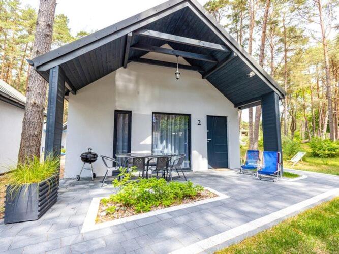 Casa con patio con sillas y mesa en Comfortable holiday cottages, Jaros awiec en Jarosławiec