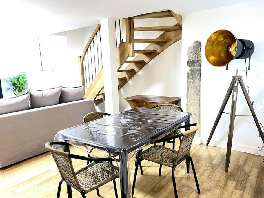 - une table et des chaises dans le salon avec un escalier dans l'établissement Duplex avec terrasse en hypercentre de Grenoble, à Grenoble