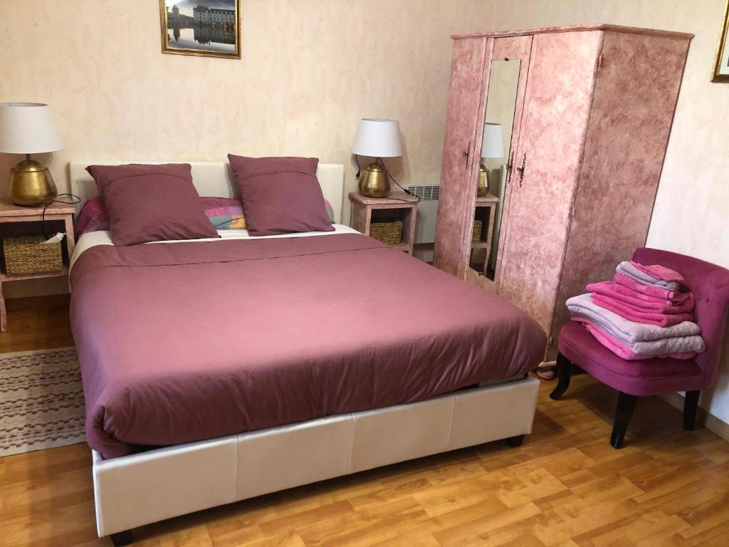 1 dormitorio con 1 cama grande y 1 silla en L'Eclipse, en Saint-Nicolas-des-Motets