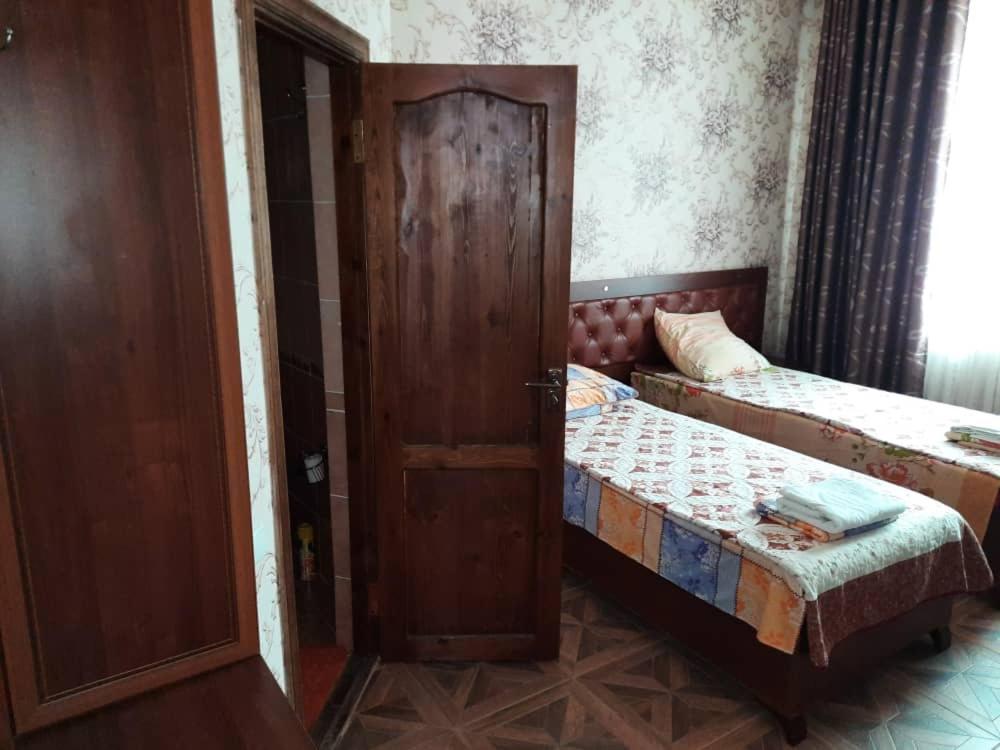 a room with two beds and an open door at Inn Sogdiana in Panjakent