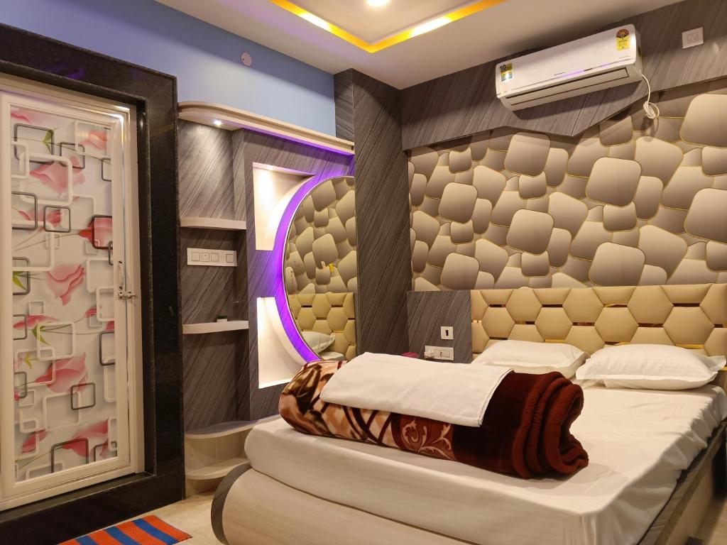 a bedroom with two beds and a mirror at Uttara Residency in Siliguri