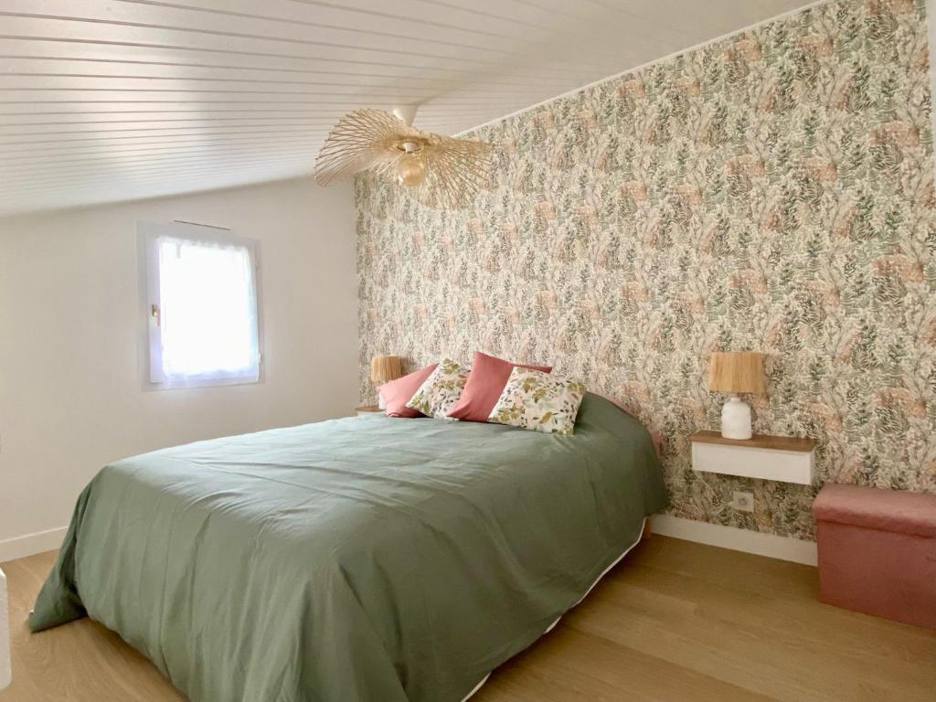 1 dormitorio con cama verde y almohadas rosas en Maison proche centre, gare, aux Sables d'olonne en Les Sables-dʼOlonne