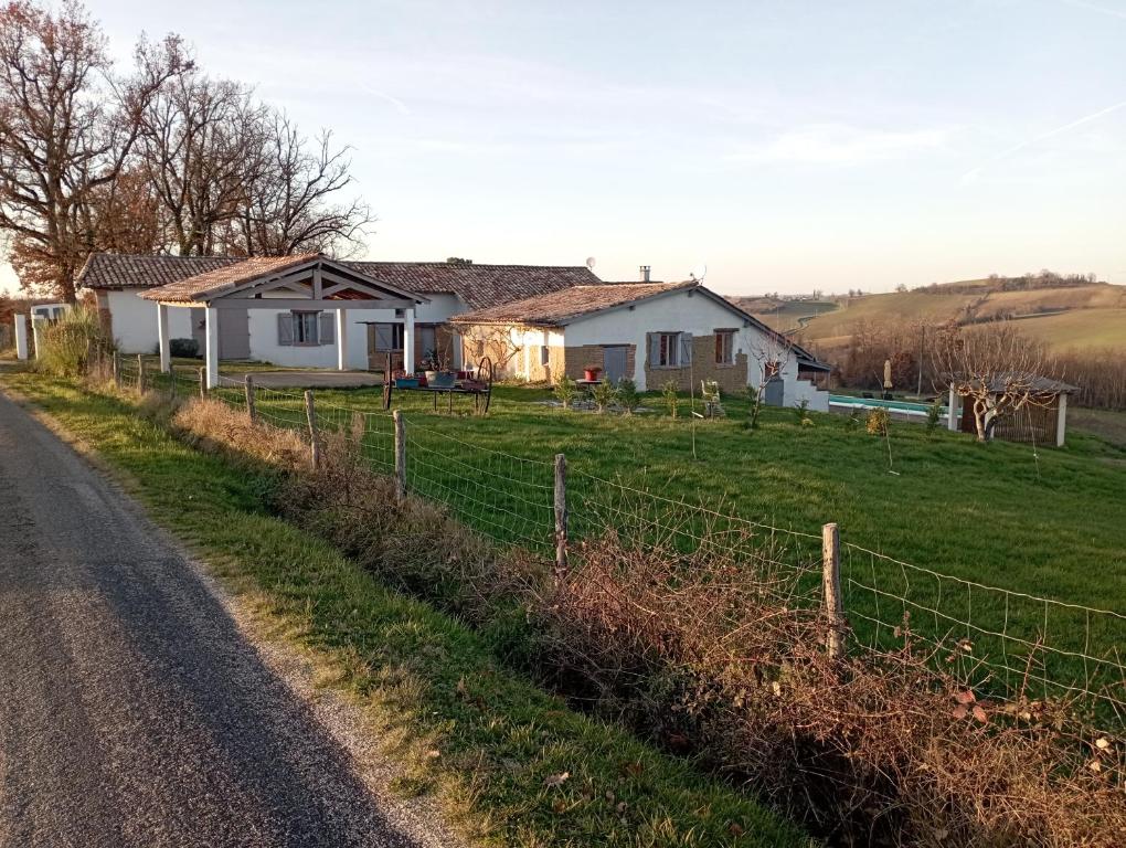 une maison sur le côté d'une route avec une clôture dans l'établissement Havre de paix a la campagne, à Puycornet