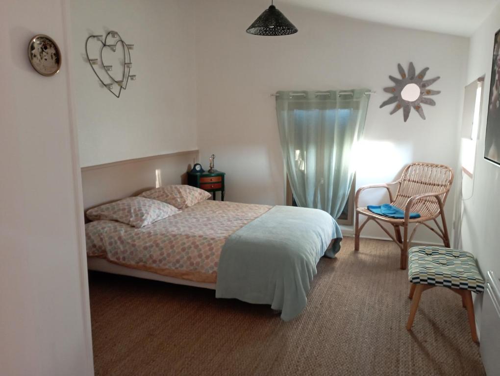 ein Schlafzimmer mit einem Bett, einem Tisch und einem Stuhl in der Unterkunft Havre de paix a la campagne in Puycornet