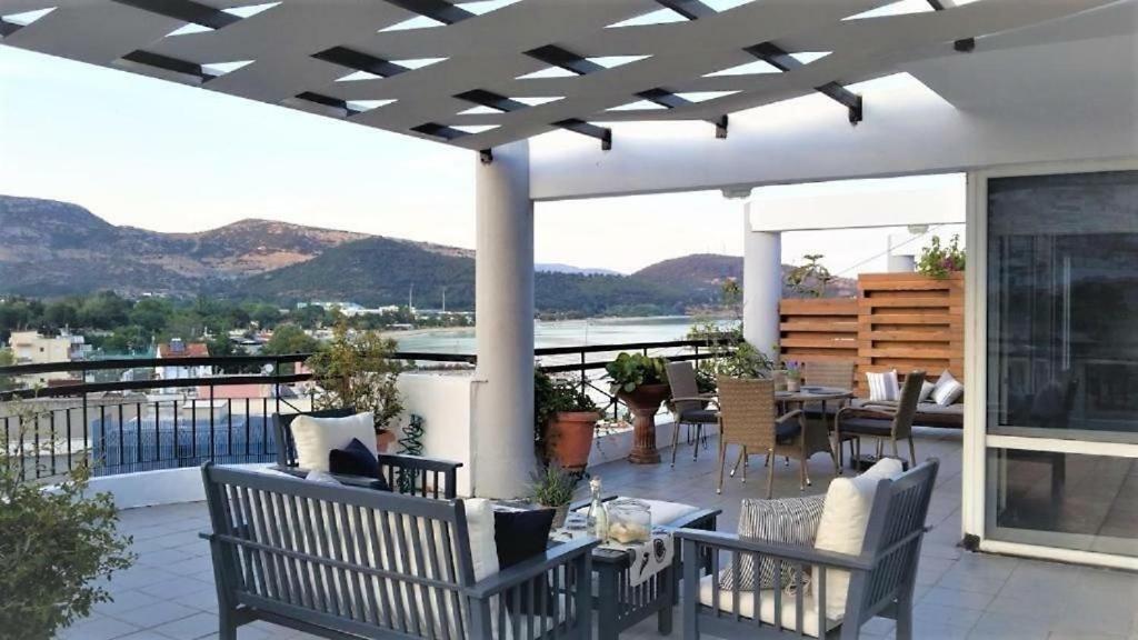 a patio with chairs and tables on a balcony at Port View Suite, Kavala in Kavala