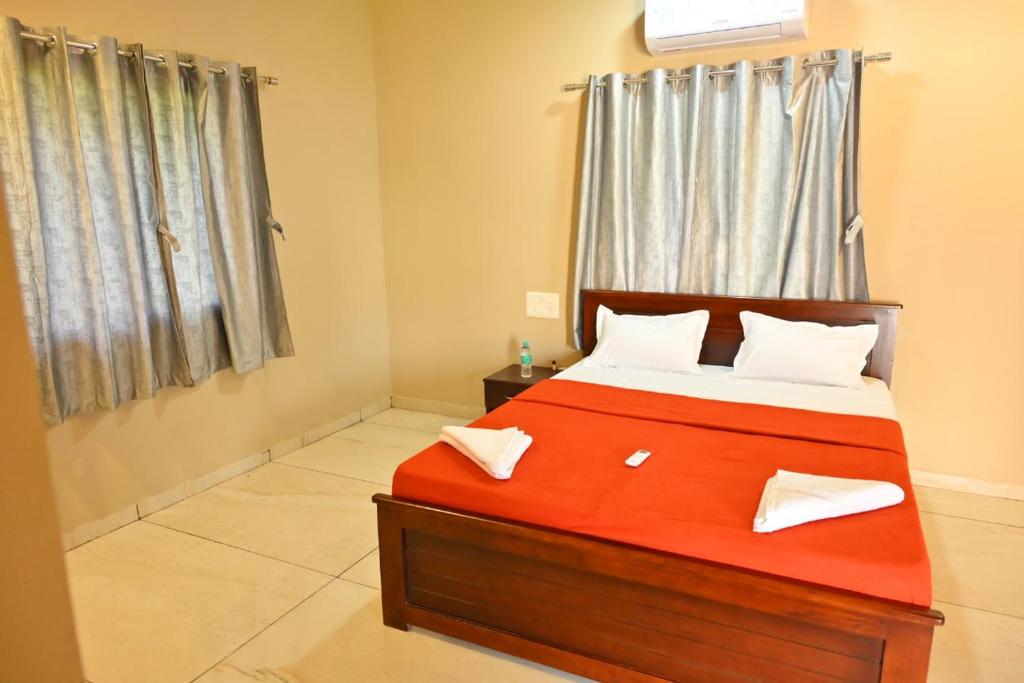 a bedroom with a red bed and a window at Hotel Mint Leaf in Kāgal