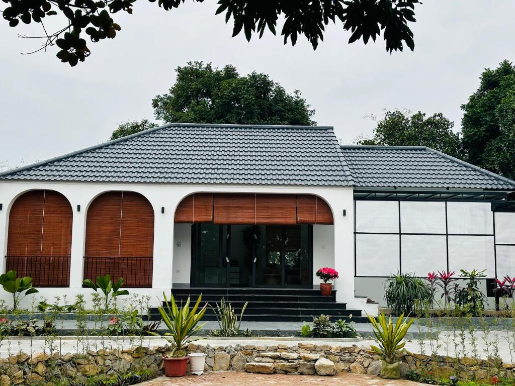 a white house with a black roof at Diep's House in Hanoi